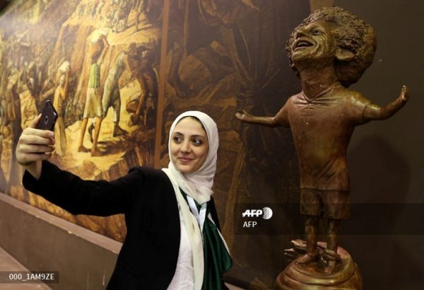 Una mujer se toma un selfie junto a una estatua del delantero egipcio de Liverpool, Mohamed Salah, que se muestra en el Foro Mundial de la Juventud en Sharm El Sheikh, el 5 de noviembre de 2018. AFP